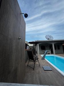 a patio with a chair and a swimming pool at Casa de Praia com Piscina e Espaço Gourmet in Bertioga
