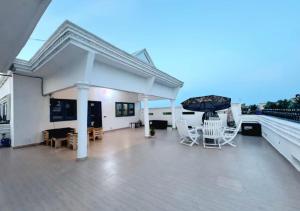 eine Terrasse mit Stühlen und einem Sonnenschirm auf einem Dach in der Unterkunft Hôtel 550 in Cotonou Cadjehoun