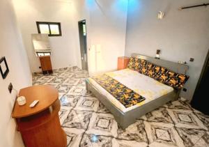 ein kleines Schlafzimmer mit einem Bett und einem Tisch in der Unterkunft Hôtel 550 in Cotonou Cadjehoun