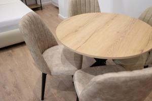 a wooden table with two gray chairs around it at Hotel Petro in Vlorë