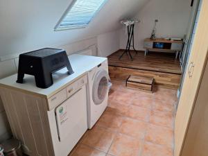 a laundry room with a washing machine and a window at Ferienwohnung Alte Schule in Lonnerbecke