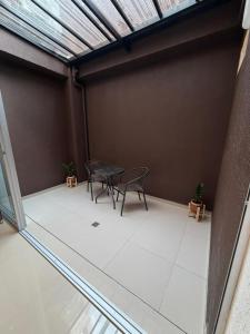 a patio with two chairs and a table in a room at Las Lilas - 102 in Cali +1 photo