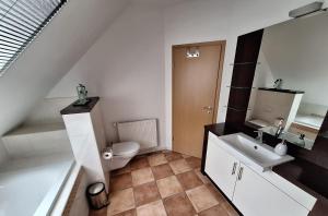 a white bathroom with a toilet and a sink at Ferienwohnung Alte Schule in Lonnerbecke +14 photos