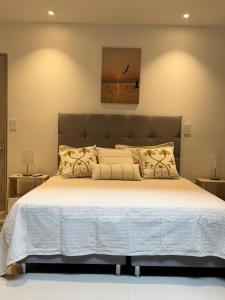 a bedroom with a large bed with white sheets and pillows at Las Lilas - 102 in Cali