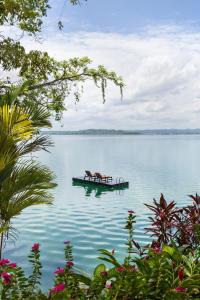 two horses on a dock in the middle of a lake at Bolontiku Boutique Hotel Member of the Cayuga Collection in Flores