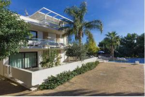 a house with a palm tree in front of it at Giardino del carrubo in Marina di Ragusa