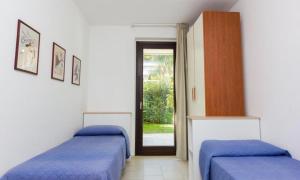 two beds in a room with blue sheets at Giardino del carrubo in Marina di Ragusa