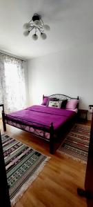 a purple bed in a bedroom with a ceiling fan at Апартамент ШАХОВ in Tŭnkovo +31 photos