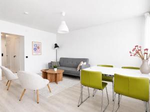 a living room with a table and green chairs at Galle's 2 bedroom penthouse in Pori