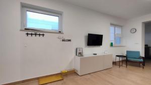 a white room with a window and a tv on a wall at Apartma WALK in in Brežice