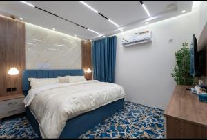 a bedroom with a large bed with a blue headboard at جناح اميري in Ash Shishah