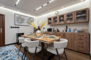 a kitchen with a wooden table and some chairs at جناح اميري in Ash Shishah