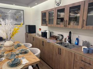 a kitchen with wooden cabinets and a table with chairs at جناح اميري in Ash Shishah +13 photos