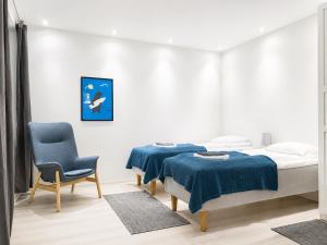 a bedroom with two beds and a chair at Galle's 2 bedroom penthouse in Pori