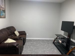 a living room with a couch and a tv at Karis Home in Airdrie +14 photos