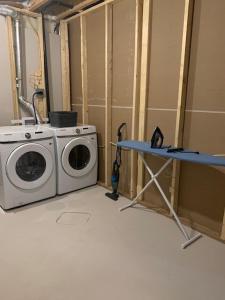 a laundry room with a washing machine and a table at Karis Home in Airdrie