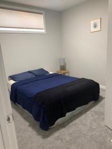 a bedroom with a blue bed and a window at Karis Home in Airdrie