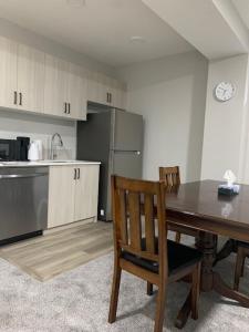 a kitchen with a wooden table and a wooden chair at Karis Home in Airdrie