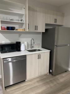 a kitchen with a sink and a refrigerator at Karis Home in Airdrie