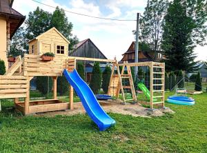 a playground with a slide and a play structure at Apartamenty 242E in Chochołów