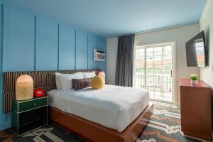 a bedroom with a large bed with a large window at Driftaway Hotel and Pool in Ogunquit +76 photos