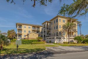 an apartment building with a palm tree in front of it at Sea Gate 303 in Saint Simons Island