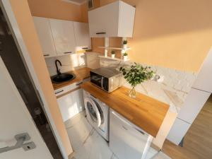 a kitchen with a washer and a microwave on a counter at Kamienica Partyzantów in Pasłęk