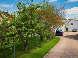 a car parked on the side of a road with trees at Kamienica Partyzantów in Pasłęk
