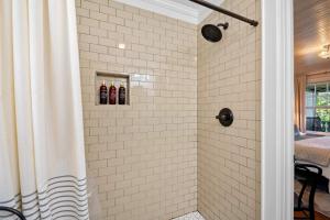a shower in a bathroom with white tiles at Historic Riverview Inn One in Chattanooga