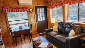 a living room with a leather couch and a table at The Couple's Cabin in Wynola 2 NIGHT MINIMUM in Julian