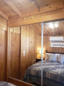 a bedroom with a bed in a wooden cabin at The Couple's Cabin in Wynola 2 NIGHT MINIMUM in Julian