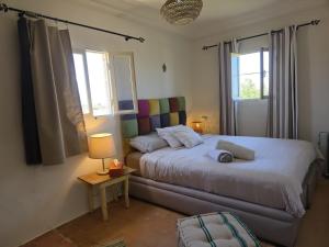 a bedroom with a bed and a table with a lamp at Beach House with Sea Views and Rooftop Terrace in Sidi Kaouki