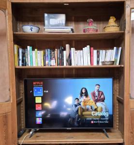 a tv in a book shelf with a tv screen at Beach House with Sea Views and Rooftop Terrace in Sidi Kaouki