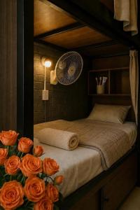 a bedroom with a bed with orange roses and a fan at Global Hanoi Backpackers in Hanoi +41 photos