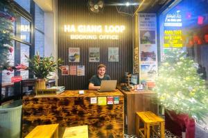 a man sitting at a counter with a laptop at Global Hanoi Backpackers in Hanoi