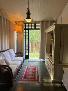 a living room with a couch and a tv at Pousada A Casa da Fazenda in Santo Antônio do Pinhal