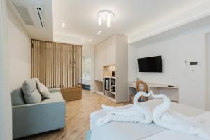 zwei weiße Schwäne sitzen auf einem Bett in einem Wohnzimmer in der Unterkunft Pasitea in Terrasini