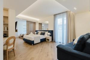 ein Schlafzimmer mit einem Bett und ein Wohnzimmer mit einer Couch in der Unterkunft Pasitea in Terrasini