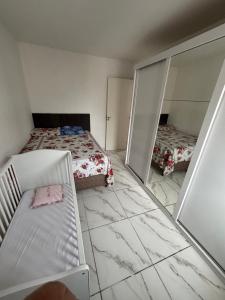 a bedroom with two beds and two mirrors at Lazer Oceanos in São Vicente