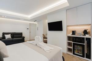 ein Schlafzimmer mit einem weißen Bett und einem Fernseher in der Unterkunft Pasitea in Terrasini