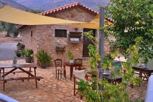 a patio with tables and chairs and a building at VILLA IN THE OLIVE TREES Galaxidi in Galaxidi