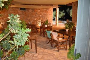 an outdoor patio with wooden tables and chairs at VILLA IN THE OLIVE TREES Galaxidi in Galaxidi