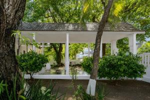 a white gazebo in a yard with trees at Cabrero House Boutique in Cartagena de Indias