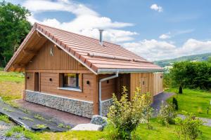a small wooden cabin with a red roof at EPIC CHALETS - 4 et 5 étoiles - Spa privatif - Gérardmer in Granges-Aumontzey