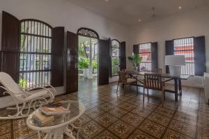 a living room with a table and chairs and windows at Cabrero House Boutique in Cartagena de Indias