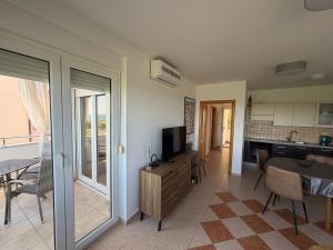 a living room with a television and a table with chairs at Apartman with sea view KAVALA- Pašman, Kraj in Kraj