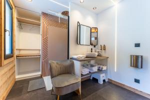 a dressing room with a chair and a mirror at EPIC CHALETS - 4 et 5 étoiles - Spa privatif - Gérardmer in Granges-Aumontzey +112 photos