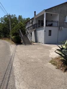 a building with a staircase on the side of the road at Apartman M&S in Golubovci