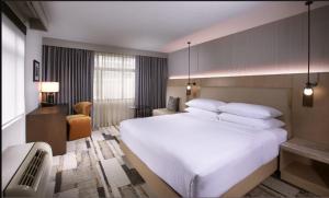 a bedroom with a large white bed and a chair at The Paramount Hotel in Seattle