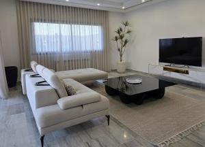 a living room with a couch and a table at Villa Sunrise in Hammamet